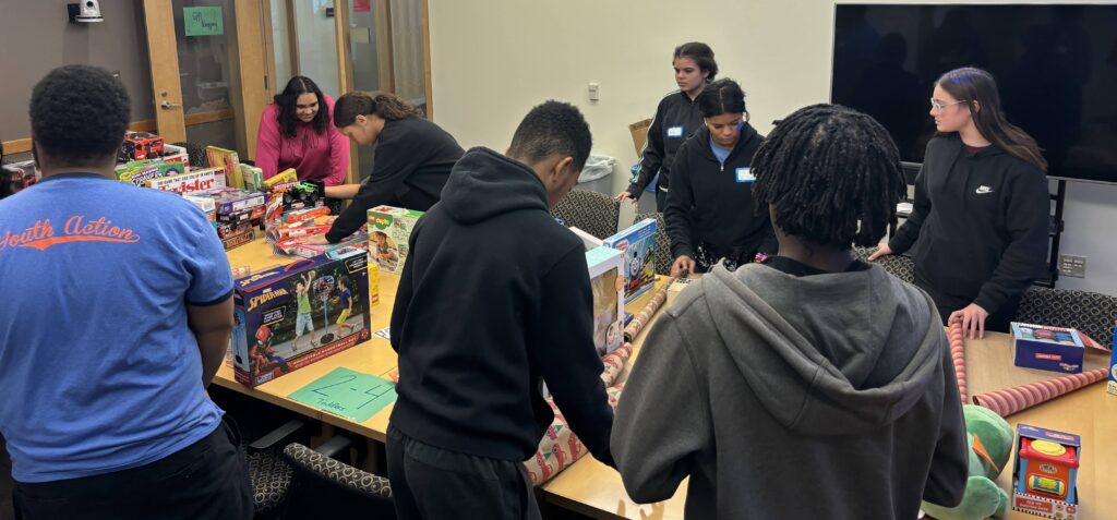 Youth Action students wrapping holiday gifts for annual toy drive